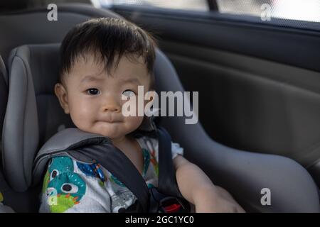 Asiatische chinesische junge sitzen in einem Auto in Sicherheitsstuhl Stockfoto