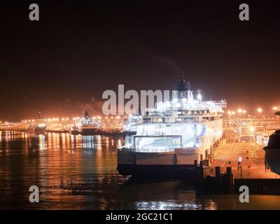 Calais, Frankreich - 5. Februar 2017. Leuchtendes Fährschiff im Hafen von Mitternacht. Alle Autos, Busees und LKWs sind bereits beladen und das Boot ist bereit zum Verlassen Stockfoto