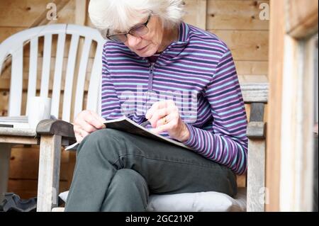 Ältere ältere Menschen halten Geist aktiv durch Kreuzworträtsel Stockfoto
