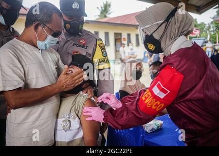 Kendari, Indonesien. August 2021. Ein Gesundheitsmitarbeiter verabreicht einer behinderten Person eine Dosis des Sinovac COVID-19-Impfstoffs.die Polizeiimpfstelle Kendari führte eine Impfoperation für Menschen mit Behinderungen auf der Polizeiwache Poasia in Kendari durch. Dutzende von behinderten Personen wurden in ihren jeweiligen Häusern mit Polizeifahrzeugen für ihre erste Dosis des Sinovac-Covid-19-Impfstoffs abgeholt. (Foto von Andry Denisah/SOPA Images/Sipa USA) Quelle: SIPA USA/Alamy Live News Stockfoto