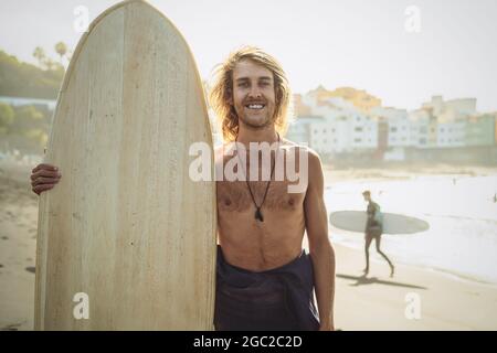 Junge Surfer, die Spaß haben, einen Surftag bei Sonnenuntergang zu genießen - Extreme Sport Lifestyle People Concept Stockfoto