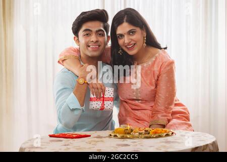 EINE GLÜCKLICHE SCHWESTER UND EIN BRUDER POSIEREN VOR DER KAMERA AUF RAKSHABANDHAN Stockfoto