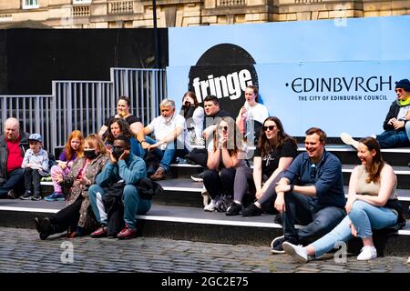 Edinburgh, Schottland, Großbritannien. August 2021. Bilder von der Royal Mile in der Altstadt von Edinburgh am Eröffnungstag des Edinburgh Fringe Festivals 2021. Das Festival sieht ganz anders aus als vor zwei Jahren. Nur sehr wenige Straßenaufführungsräume sind erlaubt und deutlich weniger Touristen sind zu sehen. Auch eine hohe Sichtbarkeit der Polizei, es gibt mehr Polizeibeamte als Darsteller auf der Straße, steht in einem deutlichen Kontrast zu den Vorjahren. Bild: Zuschauer beobachten den Darsteller in einem abgeschirmten Raum in der St Gile Cathedral. Iain Masterton/Alamy Live Nachrichten. Stockfoto