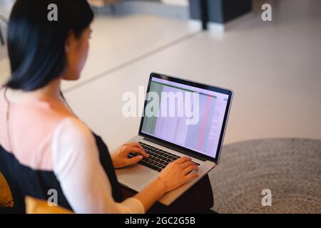 Asiatische Geschäftsfrau sitzt auf der Couch und arbeitet auf dem Laptop Stockfoto