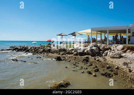 Porec, Kroatien - 10. Juli 2021. Urlauber und Einheimische entspannen sich an einer Strandbar am Parentino Beach außerhalb der historischen Küstenstadt Porec Stockfoto
