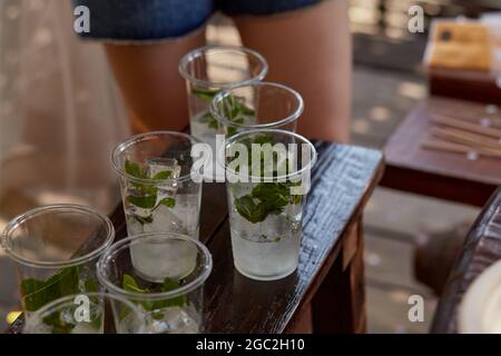 Junge Frau auf einer Junggesellinnenparty macht einen Mojito-Cocktail für die Firma. Anweisungen zur Vorbereitung. Schritt 3. Hochwertige Fotos Stockfoto