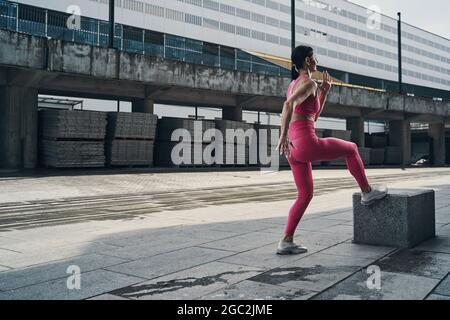 Sportsperson macht Aufwärm-Übung auf der Straße Stockfoto