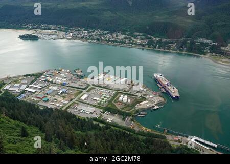 Juneau, Alaska, Juli 2021. Überblick über das Hafengebiet von Juneau, den Gastineau-Kanal und ein großes Kreuzschiff, das dort von der Goldbelt Mount Roberts Tramway über der Stadt angedockt ist. Stockfoto