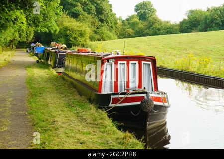 An einem Sommerabend vor dem walisischen Dorf Chirk in Nordwales vertäuten am Llangollen-Kanal Schmalbooten oder Lastkähne Stockfoto