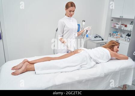 Fröhliche weibliche professionelle tun Massage für Kunden Stockfoto