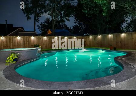 Ein Pool im Hinterhof und ein Whirlpool, der nachts heiß ist Stockfoto