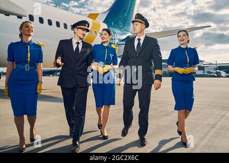 Flieger und wunderschöne Flugbegleiter gehen voran Stockfoto