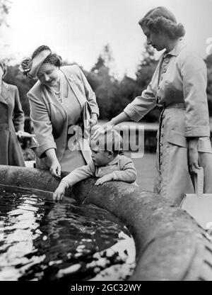 Die Königin (jetzt Königin Mutter), Prinzessin Margaret und Prinz Charles schauen in einen Teich, um zu sehen, ob es irgendwelche Fische während eines Familientreffens in Balmoral Castle, Schottland. August 1951. Stockfoto