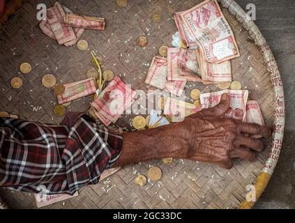 Kathmandu, Bagmati, Nepal. August 2021. Ein älterer Mann sammelt das Geld, das von Anhängern um ein Abbild eines Dämons zur Feier des Ghantakarna-Festivals in Kathmandu, Nepal, am 6. August 2021 angeboten wird. Die Gemeinde Newar im Kathmandu Valley beobachtet Ghantakarna, ein Fest, das böse Geister vertreiben und Glück einläuten soll. Die Menschen tragen Metallringe, um sich vor allem Übel und bösen Geistern zu schützen. (Bild: © Sunil Sharma/ZUMA Press Wire) Stockfoto