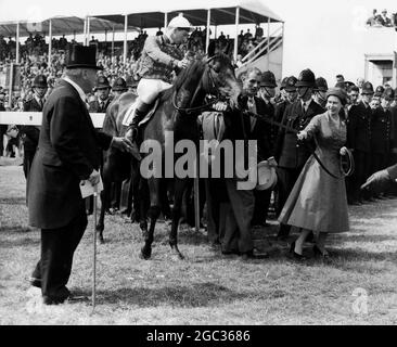 HM Queen Elizabeth II führt ihr Pferd Carrozza an, nachdem es die 179. Eichen-Einsätze gewonnen hat, mit Lester Piggott im Sattel. Auf der linken Seite befindet sich Lord Rosebery, ein Kursleiter, und in der Mitte befindet sich der Trainer der Königin, Herr Noel Murless. In einem Fotoabgang wurde Silken Gilder, geritten von J Eddery, Zweiter und Rose Royal II, die Favoritin mit J Massard im Sattel, Dritter. Juni 1957 Stockfoto