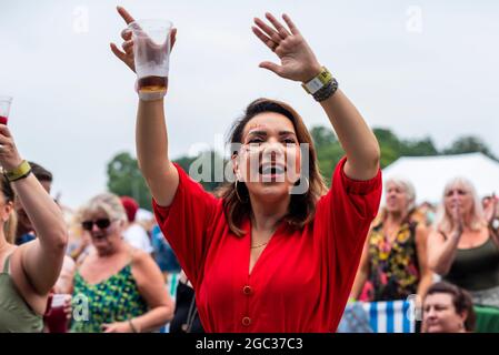 Weibliche Besucher des Konzertmusikfestivals bei der Fantasia-Veranstaltung im Promenade Park, Maldon, Essex, Großbritannien. Genießen Sie es, nach dem COVID wieder bei einem Live-Massenevent zu sein Stockfoto