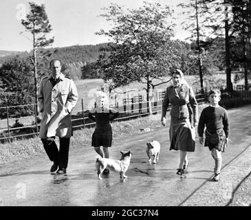 Die königliche Familie schlendern. Königin Elizabeth, der Herzog von Edinburgh und ihre beiden Kinder Prinz Charles und Prinzessin Anne begleitet von der Familie Corgi zu Fuß durch das Balmoral Castle Estate 18. September 1957 Stockfoto