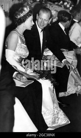 Der Herzog von Edinburgh wendet sich an die Königin Elizabeth II., die ihren Platz in der Royal Box für die Premiere des Films The Guns of Navarone am 27. April 1961 einnehmen wird Stockfoto