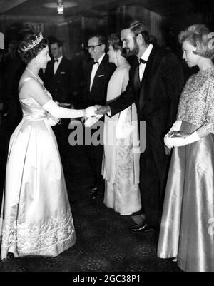 Her Majesty The Queen Elizabeth II bei der Filmpremiere schüttelt Stanley Baker die Hand einer der Stars im Film The Guns of Navarone auf der rechten Seite ist Mrs Stanley Baker 27 April 1961 Stockfoto