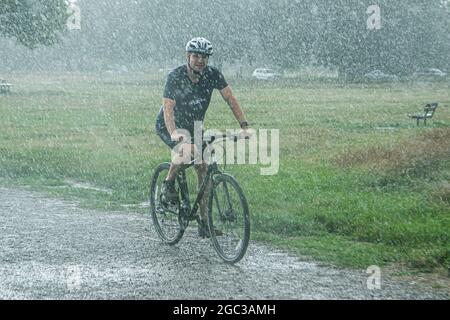 WIMBLEDON LONDON, 6. August 2021. Ein Radfahrer, der während eines Regenguß auf Wimbledon Common reitet. Die Prognose ist für Blitzfluten in Teilen Großbritanniens über das Wochenende.Quelle: amer ghazzal/Alamy Live News Stockfoto