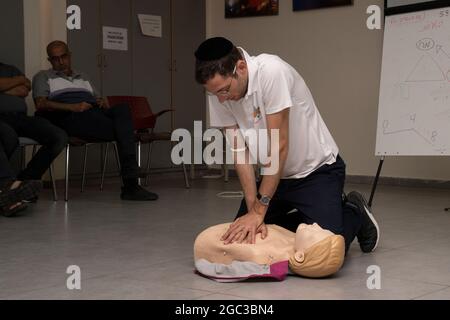 Tel Aviv, Israel - 5. August 2021: Ein Instruktor, der in einem Kurs in Tel Aviv, Israel, die lebenstraftechnische Technik an einer CPR-Puppe vorführt. Stockfoto