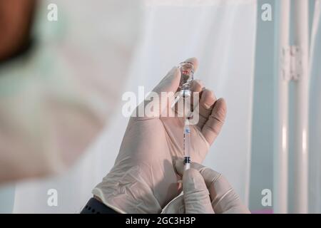 Sinovac-Coronavirus-Impfstoff und Spritze in der Flasche oder im Fläschchen zur Injektion in die Hände des Arztes. Covid-19, SARS-Cov-2-Prävention Stockfoto