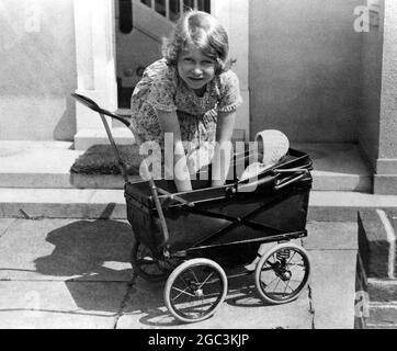 Prinzessin Elizabeth spielt mit einem Puppenwagen in dem 'kleinen Haus', das ihr von der Bevölkerung von Wales gegeben wurde und jetzt auf dem Gelände der Royal Lodge in Windsor im Jahr 1933 Y Bwthyn Bach Stockfoto