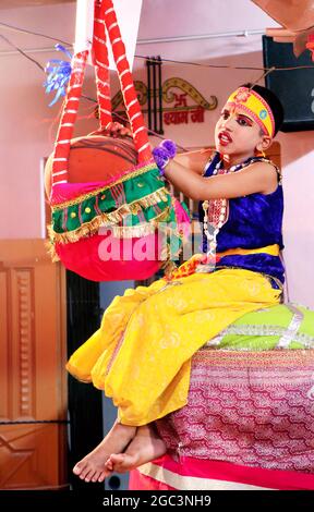 Hansi, haryana, August 2020 : EIN Kind rollt Lord Krishna mit einem Topf Butter - Janmashtami-Konzept Stockfoto