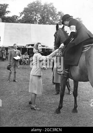 Die Royal Windsor Pferdeshow fand heute in Windsor statt. Es war der 2. Und letzte Tag der Show. Bildershow: Prinzessin Elizabeth überreicht eine Auszeichnung an Frau Duncan MacKinnon, die auf der Royal Windsor Pferdeshow in der Damenklasse auf Valvain reiten war. Juni 1946 Stockfoto