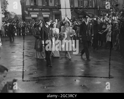 Die antike Stadt Romsey, Hampshire, war auf Hochstand, als Tausende von weit her kamen, um die ehrenwerte Patricia Edwina Victoria Mountbatten, die ältere Tochter von Viscount Mountbatten aus Burma, zu sehen, die mit Capt Lord Brabourne verheiratet war. Ihre Majestäten König und Königin mit Mitgliedern der königlichen Familie waren anwesend, ebenso wie berühmte Marine- und Militärkommandeure, die bei Viscount Mountbatten im Südosten Asiens dienten, wo sich Braut und Bräutigam trafen. Prinzessin Elizabeth, Prinzessin Margaret und Prinzessin Alexandra von Kent waren Brautjungfern. Fotoshows: Eine Hochzeitsgruppe fotografierte beim Spazierengehen Stockfoto