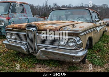 Ein vollständig intakter Edsel aus den 1950er Jahren wurde auf einem Feld weggeworfen, auf dem andere Autos warten, die auf die Wiederherstellung warten Stockfoto