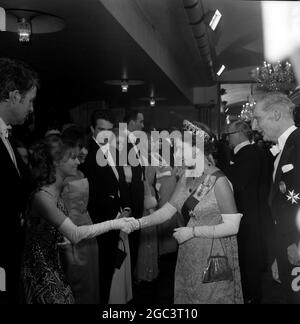 Queen Elizabeth II wird vor dem Film Born Free von Royal Film Performance 1966 mit der Schauspielerin Julie Christie abgebildet. Auf der linken Seite von Miss Christie ist der Schauspieler Bill Travers, dann Leslie Caron; Warren Beatty; Catherine Deneuve , Christopher Lee, Ursula Andress und Raquel Welch 14. März 1966 Stockfoto