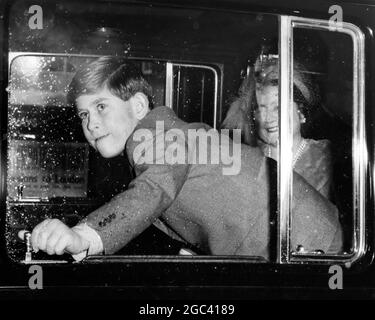 Prinz Charles bei der Mountbatten Hochzeit. Mit einem fast grimmigen Blick schließt der Prinz von Wales die Tür des Royal Car, um die Winterkälte zu verhindern, als die königliche Partei zur Hochzeit von Lady Pamela Mountbatten aufbricht. Mit lächelnder Zustimmung blickt Ihre Majestät Königin Elizabeth im Hintergrund 13. Januar 1960 Stockfoto