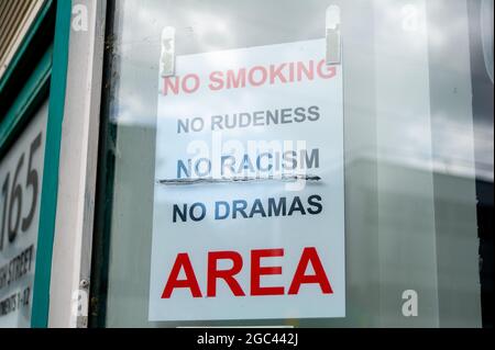 Slough, berkshire, Großbritannien. August 2021. Ein No Smoking, No Rodeness, No Racism, No Dramas Schild im Fenster eines Gemeinschaftscafés in Slough. Quelle: Maureen McLean/Alamy Live News Stockfoto