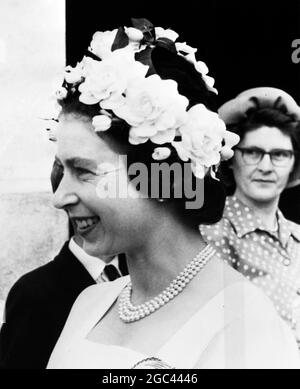 Königin Elizabeth II. Lächelt fröhlich unter ihrem weißen Ring o' Roses Hut, während sie mit Bauern und ihren Familien spricht, während sie heute die Farmen des Herzogtums Cornwall in der Nähe von Saltash besucht. 25. Juli 1962 Stockfoto