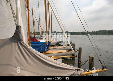 Wroxham, Norfolk Broads, Großbritannien – Juli 2021. Während der jährlichen Segelregatta festten Segelboote entlang der hölzernen Bühne an der Seite von Wroxham Broad Stockfoto