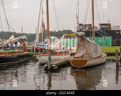 Wroxham, Norfolk Broads, Großbritannien – Juli 2021. Während der jährlichen Segelregatta festten Segelboote entlang der hölzernen Bühne an der Seite von Wroxham Broad Stockfoto