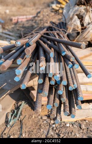 Verstärkte Stahlstäbe auf dem Hintergrund der Baustelle mit Kopierfläche. Metallsockel aus Stahlbetonwänden und Gebäuden. Stockfoto