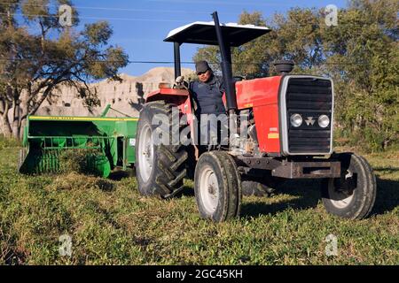 Ein Traktor, der eine Heupresse auf einem Navajo-Reservat in New Mexico zieht Stockfoto