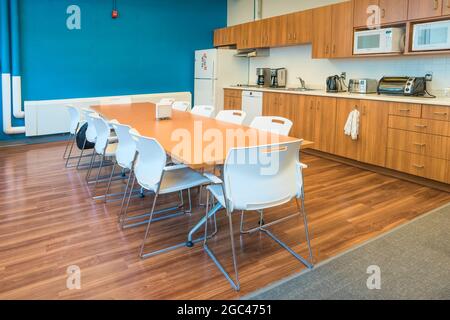 Büroküche und Esszimmer mit großem Tisch und Stühlen Stockfoto