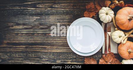 Banner mit festlich geschmücktem Teller, Serviette und Besteck an einem Thanksgiving Day Tisch, aufgenommen von der flachen Laie oder von oben aus gesehen. Pumpe Stockfoto