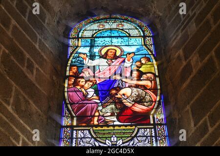 SAINT JUNIEN, FRANKREICH - 30. DEZEMBER 2020: Glasfenster in der Kirche mit Jesus Christus und Menschen, die um Heilung bitten Stockfoto