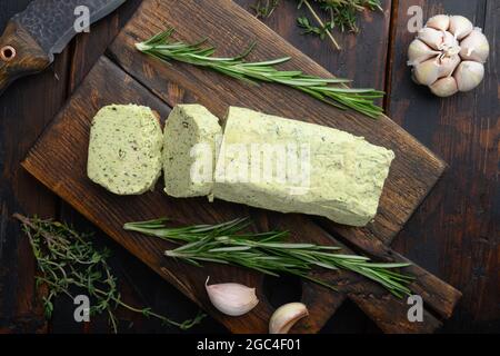 Portion Kräuterbutter mit Schnittlauch, Basilikum, Oregano, Petersilie-Set, auf altem dunklen Holztisch-Hintergrund Stockfoto