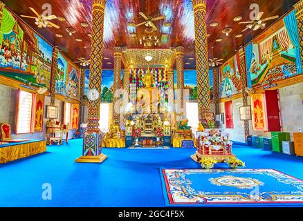 LAMPHUN, THAILAND - 8. MAI 2019: Die Gebetshalle des Wat Chammathewi Assembly Hall (Viharn) mit verzierten Säulen, Holzdecke und goldenem Buddha auf der Th Stockfoto