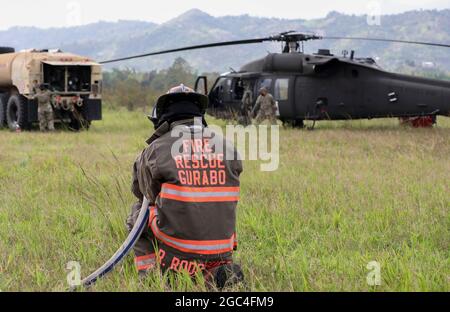 Ein Feuerwehrmann der Gemeinde Gurabo steht während der Betankung des Hubschraubers UH-60 Black Hawk in Gurabo, Puerto Rico, am 22. Mai 2021 für einen Brandfall bereit. Der Gouverneur von Puerto Rico, Pedro Pierluisi, aktivierte die Nationalgarde zur Unterstützung der Feuerwehr von Puerto Rico, um Brände in den Gemeinden Gurabo und Cayey zu bekämpfen, um die Gesundheit, das Wohlbefinden und das Eigentum der Bewohner zu schützen. (USA Foto der Armee-Nationalgarde von Staff Sgt. Marimar Rivera Medina) Stockfoto