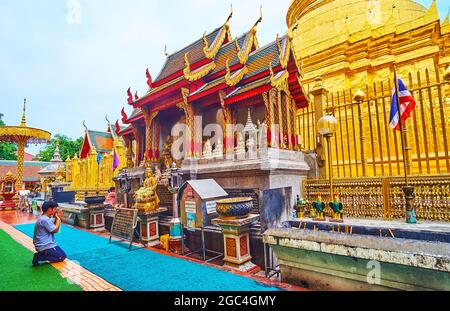 LAMHPUN, THAILAND - 8. MAI 2019: Buddhistischer Anhänger betet am Altar von Phra Maha, dem goldenen Chedi, der Reliquien Buddhas enthält und sich im Wat Ph Stockfoto