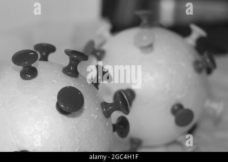 Graustufen-Aufnahme von COVID-Partikelmodellen mit Papierstiften und Styroporkugeln Stockfoto
