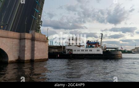 Trinity-Brücke über den Fluss Neva angehoben; Schlepper schieben Barge darunter, um 3:43 Uhr, Blick von Kutuzov Damm, St. Petersburg, Russland Stockfoto