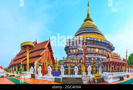 Panoramablick auf Wat Phra That Lampang Luang Tempel mit großen Kupfer Chedi und der Viharn Luang hinter dem chatra Schirm, Lampang, Thailand Stockfoto