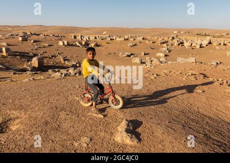 Dorfkinder spielen zwischen den Ruinen der historischen Stadt Shuayip, bekannt als Ozkent Dorf, das dem Propheten Shuayb gemunkelt wird. Stockfoto